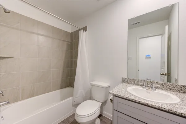 a bathroom with a granite countertop sink toilet and shower