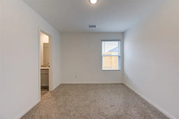 an empty room with a window and closet area