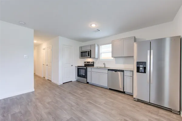a kitchen with granite countertop white cabinets and stainless steel appliances
