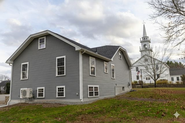 a front view of a building with trees