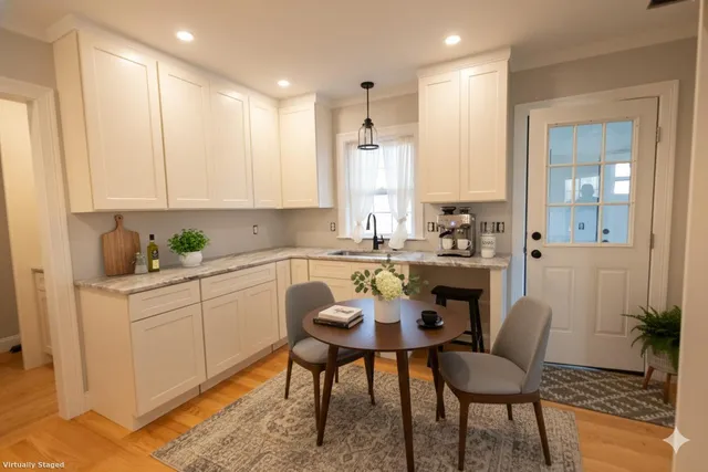 a kitchen with a dining table chairs cabinets and stainless steel appliances