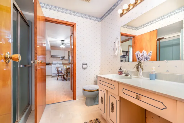 a bathroom with a sink a toilet and a mirror