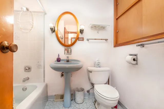 a bathroom with a sink a toilet and a mirror