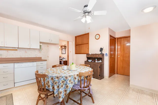a kitchen with a table chairs refrigerator and cabinets