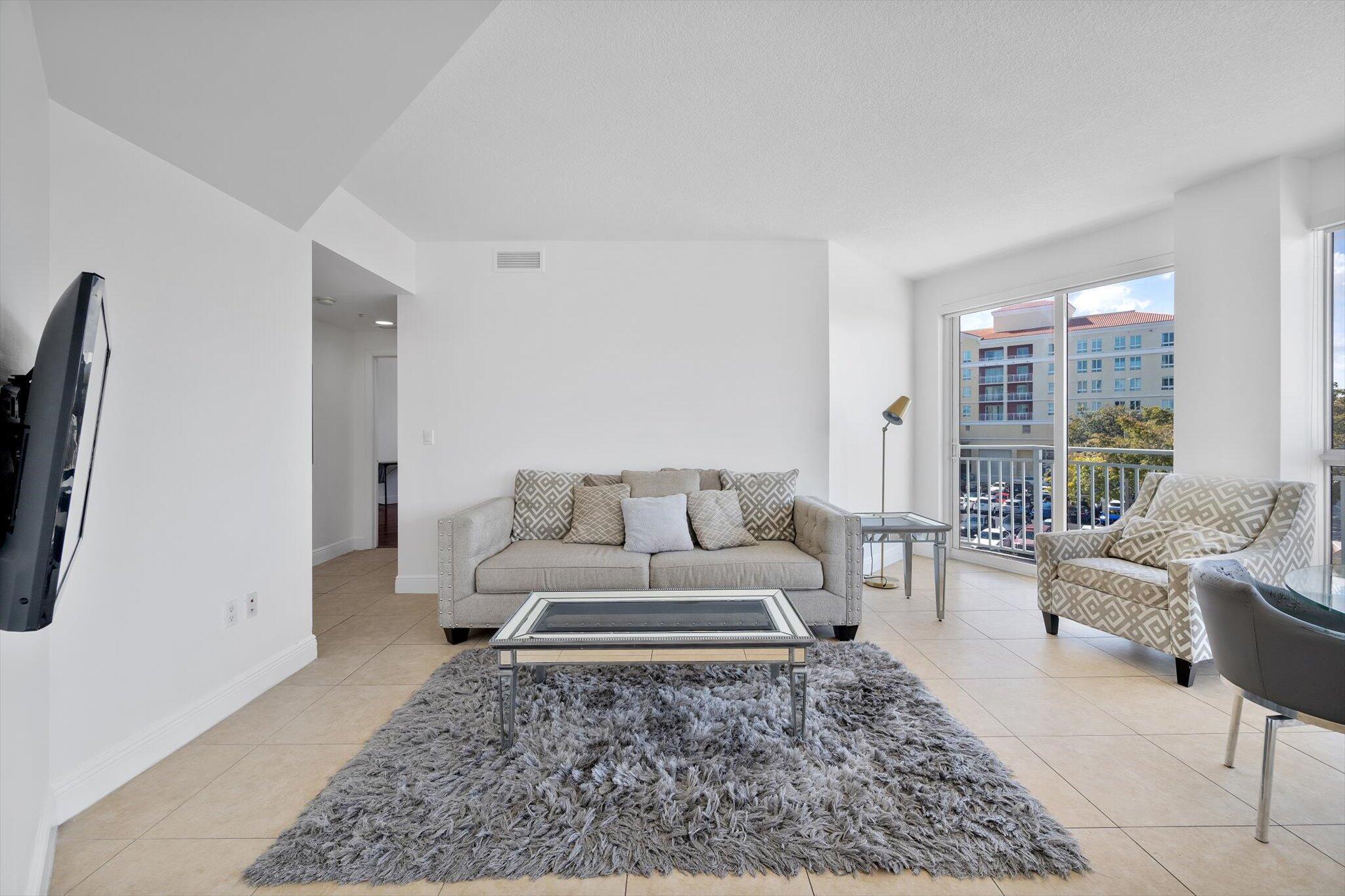 7270 Southwest 88th Street, Unit B203 Miami, FL 33156 - Photo 4 of 27 a living room with furniture and a rug