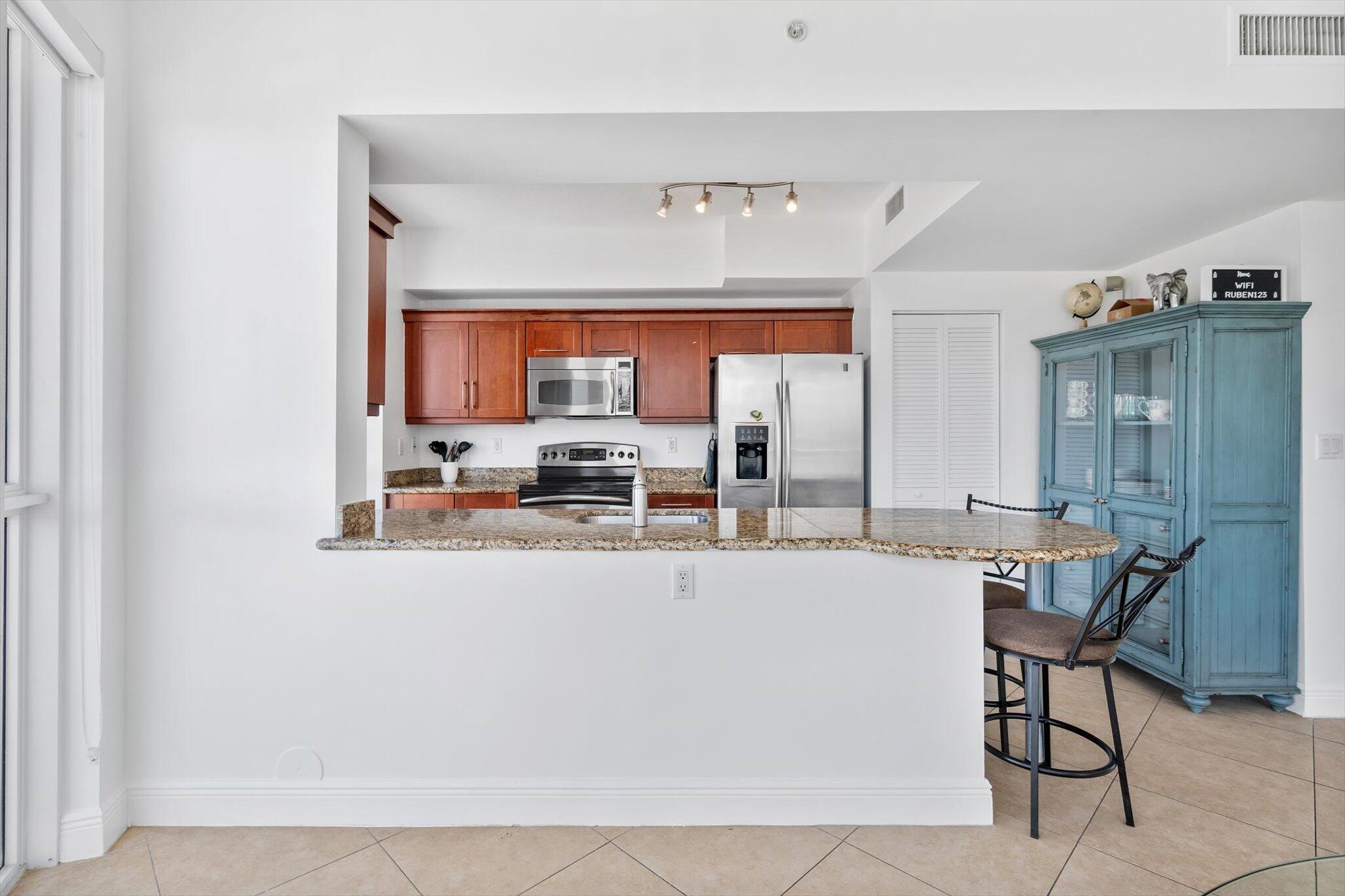 7270 Southwest 88th Street, Unit B203 Miami, FL 33156 - Photo 7 of 27 a kitchen with stainless steel appliances a table and chairs in it