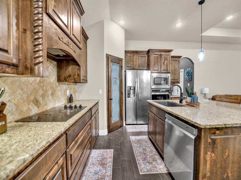 156 Cottongame Road Weatherford, TX 76088 - Photo 12 of 35 a kitchen with stainless steel appliances granite countertop a sink stove and refrigerator
