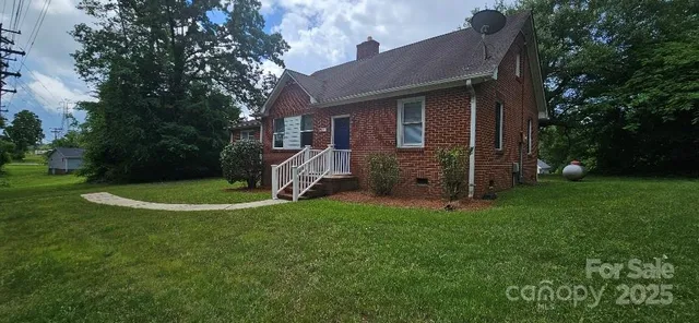 a view of a house with a backyard and a tree