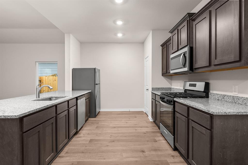 205 Southgate Drive Terrell, TX 75160 - Photo 3 of 5 a kitchen with stainless steel appliances granite countertop a stove a sink and a refrigerator