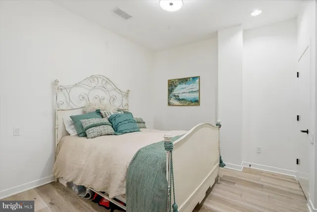 a bedroom with a bed and a painting on the wall