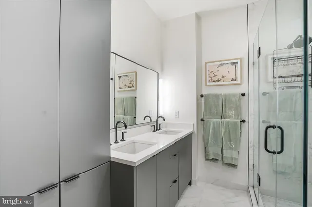 a bathroom with a granite countertop shower sink and mirror