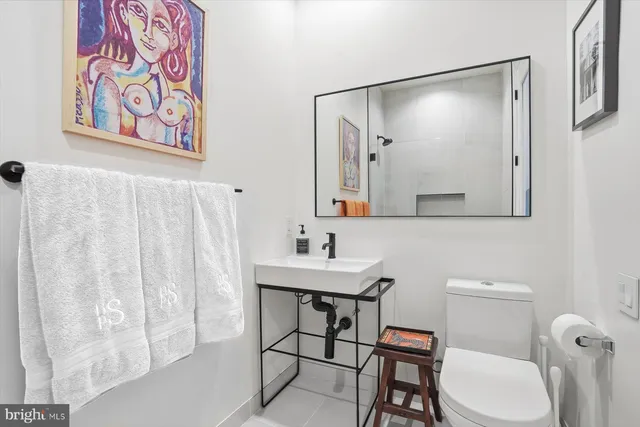 a bathroom with a toilet a sink and a mirror