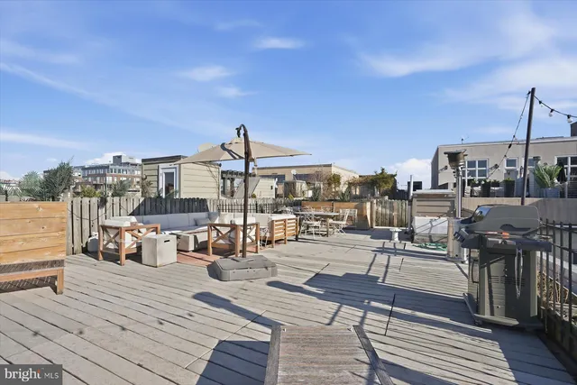a view of a roof deck with table and chairs under an umbrella