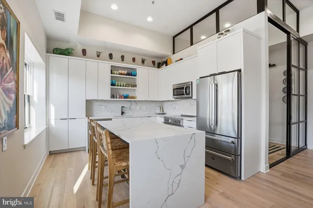a kitchen with stainless steel appliances a refrigerator sink and microwave