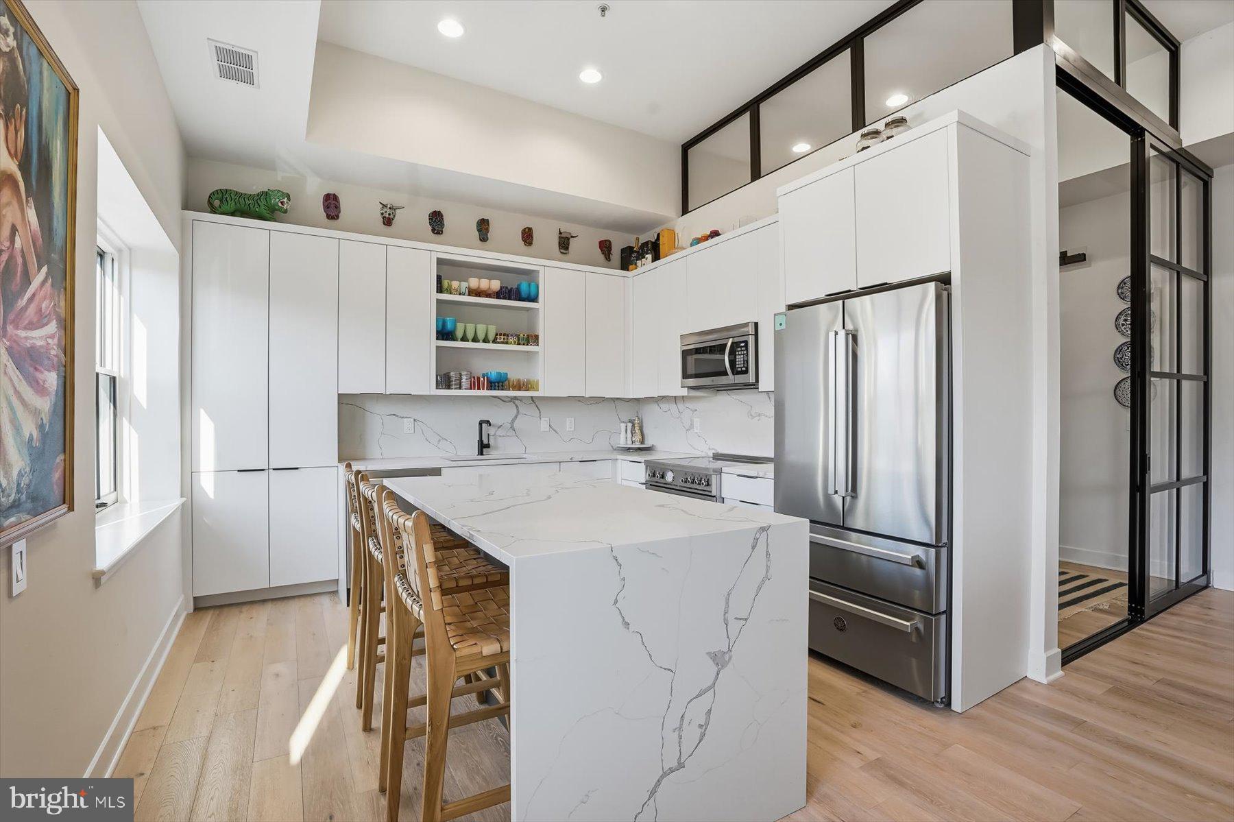 1741 Johnson Avenue Northwest, Unit 302 Washington, DC 20009 - Photo 6 of 24 a kitchen with stainless steel appliances a refrigerator sink and microwave