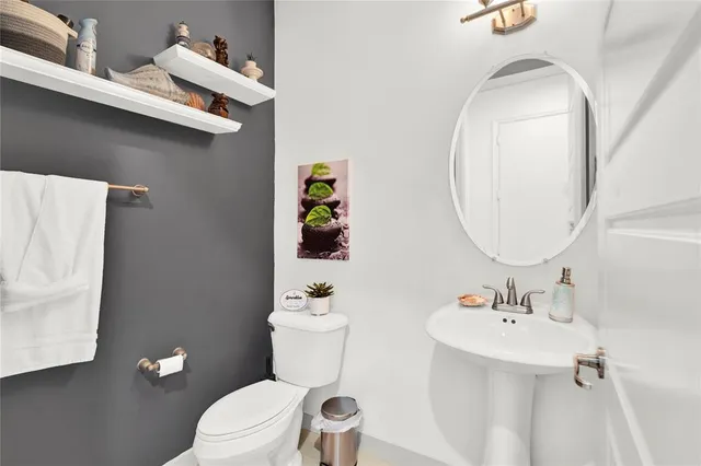 a white toilet sitting next to a bathroom sink