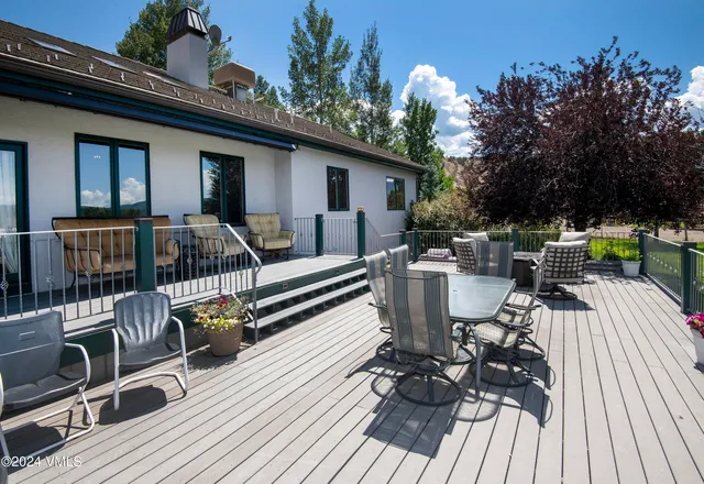 a living room with furniture a rug and a floor to ceiling window