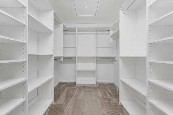 a view of walk in closet with empty racks