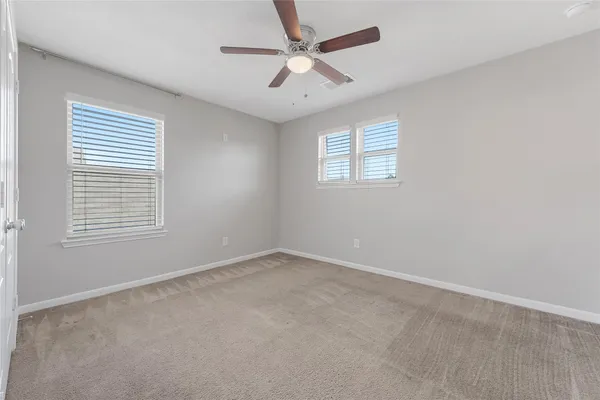 an empty room with a window and a fan