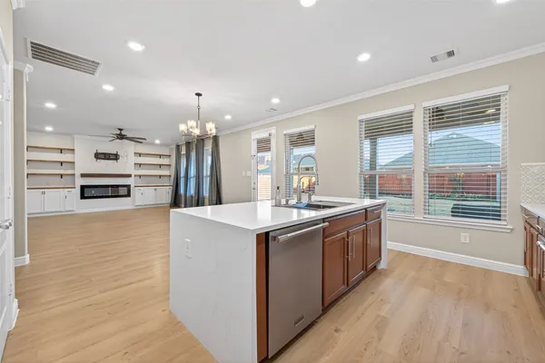 a large kitchen with stainless steel appliances a large counter top a stove a chimney a sink and a refrigerator