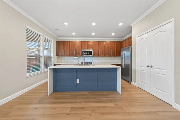 a kitchen with stainless steel appliances granite countertop a stove a sink and a refrigerator