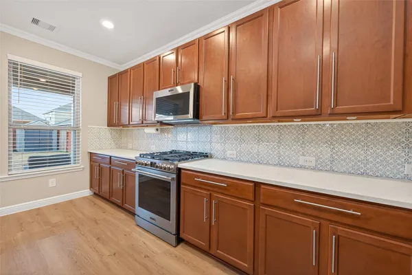 a kitchen with stainless steel appliances granite countertop a stove a sink and a microwave