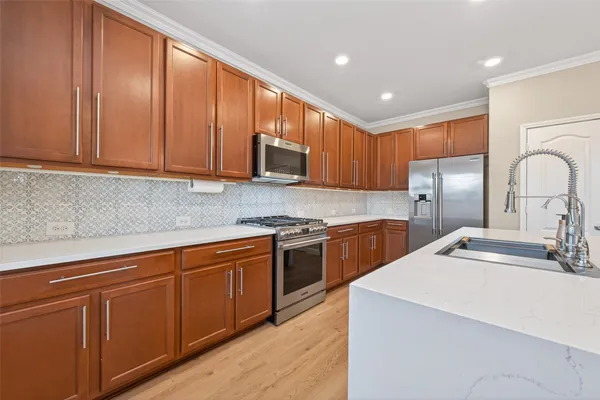 a kitchen with stainless steel appliances granite countertop a sink a stove cabinets and entryway