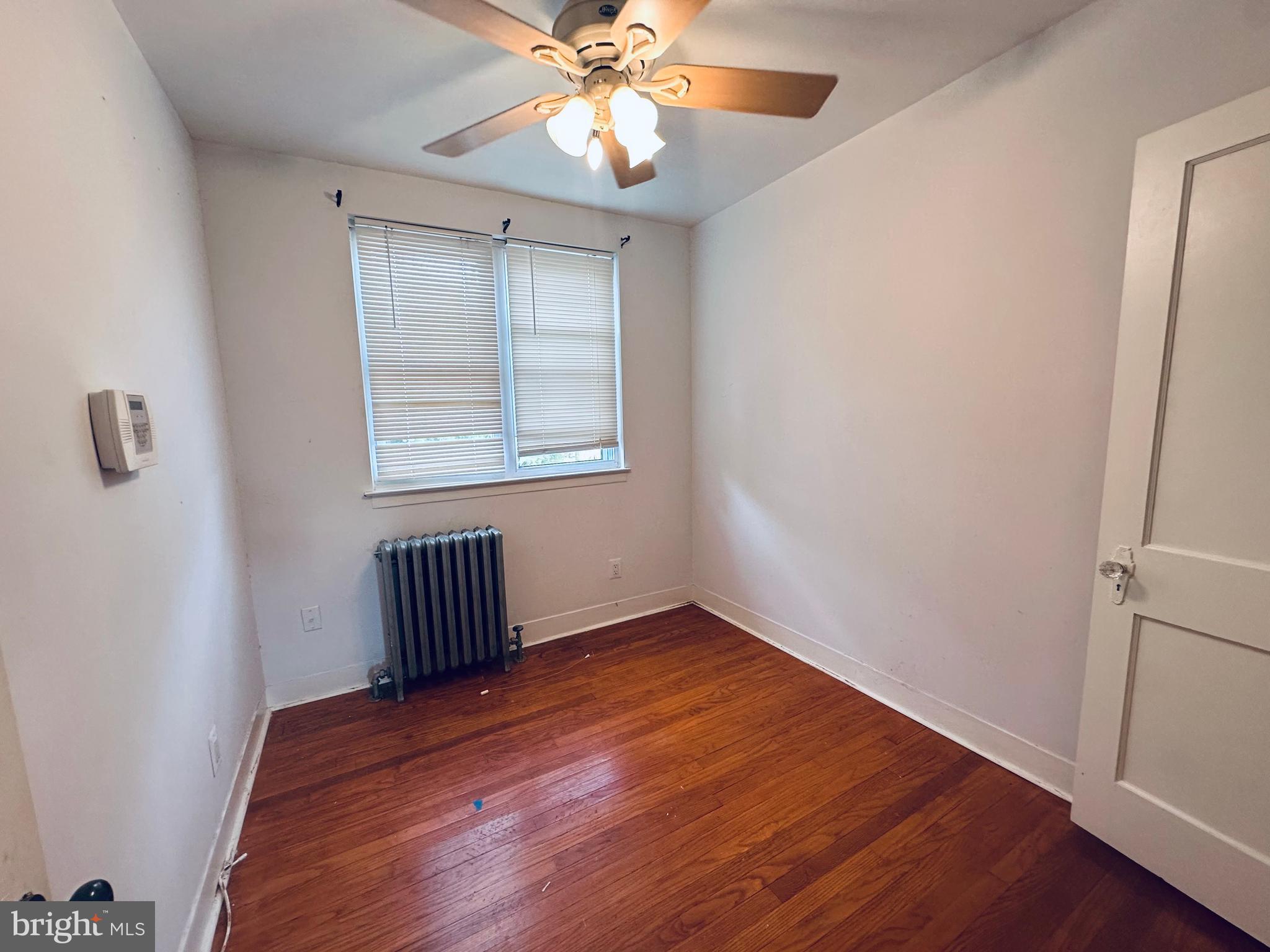 3804 Brooklyn Avenue Baltimore, MD 21225 - Photo 13 of 26 an empty room with wooden floor fan and windows
