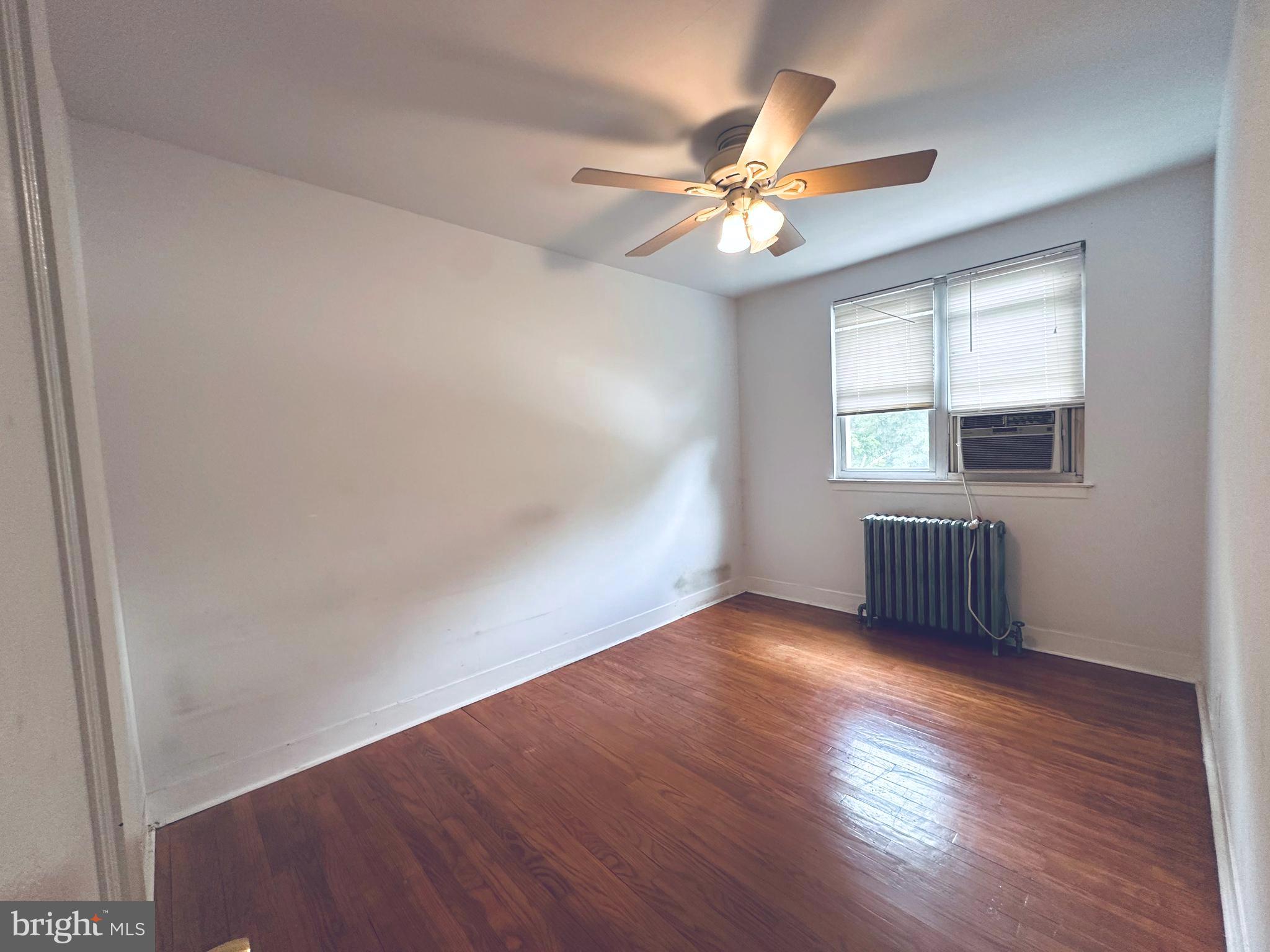 3804 Brooklyn Avenue Baltimore, MD 21225 - Photo 17 of 26 an empty room with wooden floor fan and windows