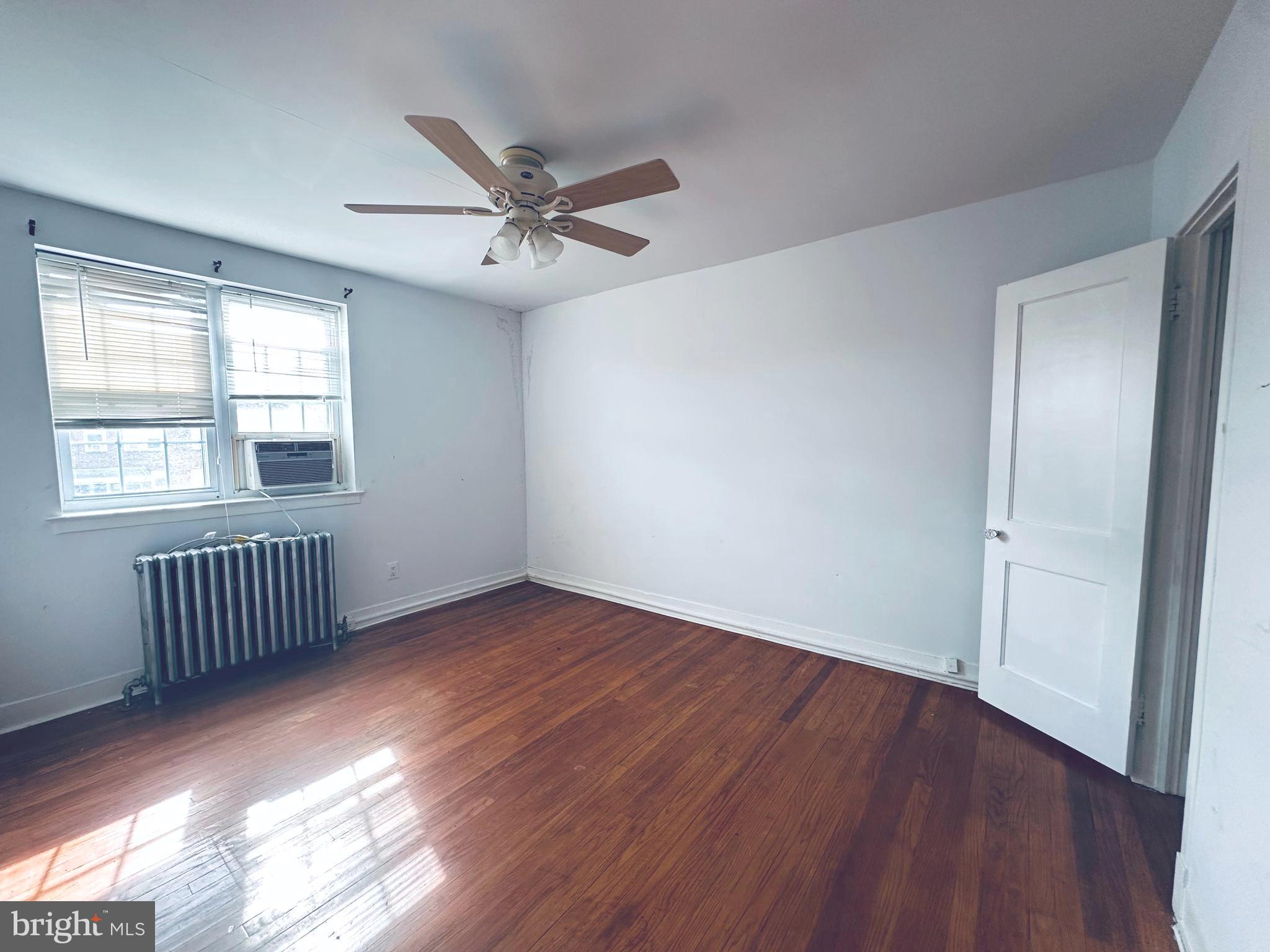 3804 Brooklyn Avenue Baltimore, MD 21225 - Photo 19 of 26 an empty room with wooden floor fan and windows