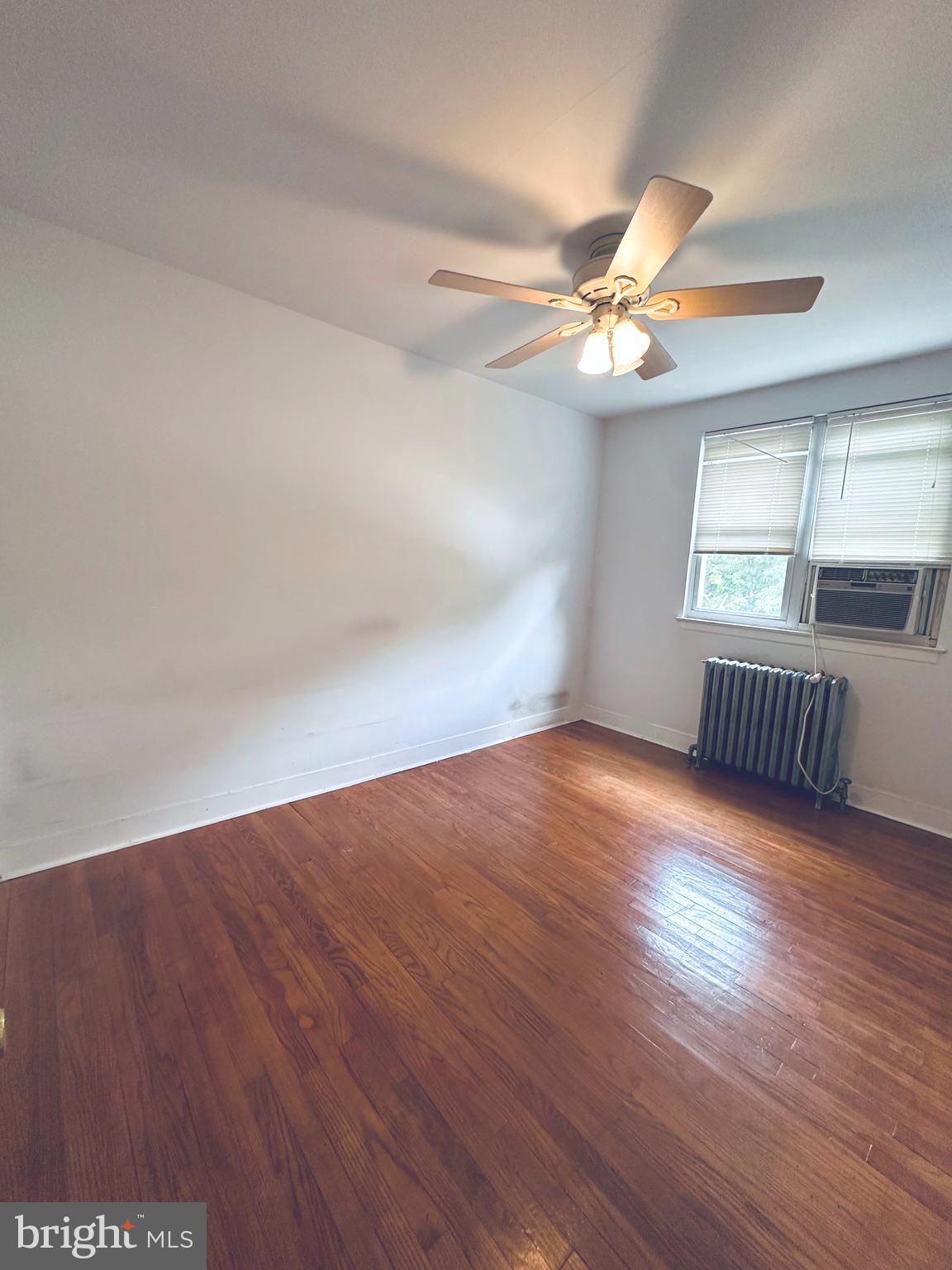 3804 Brooklyn Avenue Baltimore, MD 21225 - Photo 21 of 26 an empty room with wooden floor and windows