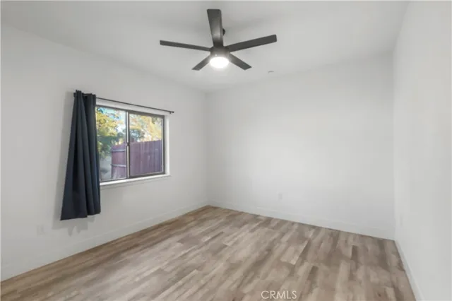 an empty room with a window and a ceiling fan