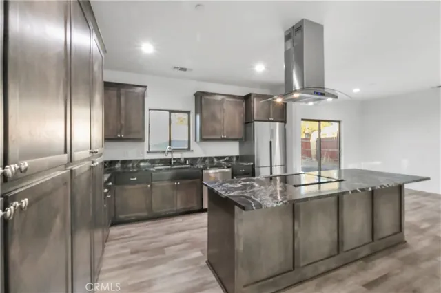 a kitchen with stainless steel appliances granite countertop a sink a stove and a refrigerator