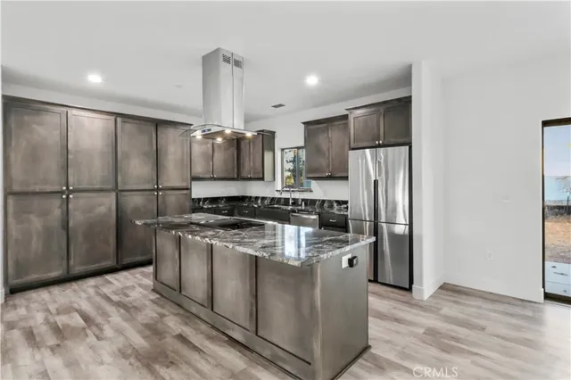 a kitchen with stainless steel appliances granite countertop a refrigerator a stove a sink and a refrigerator