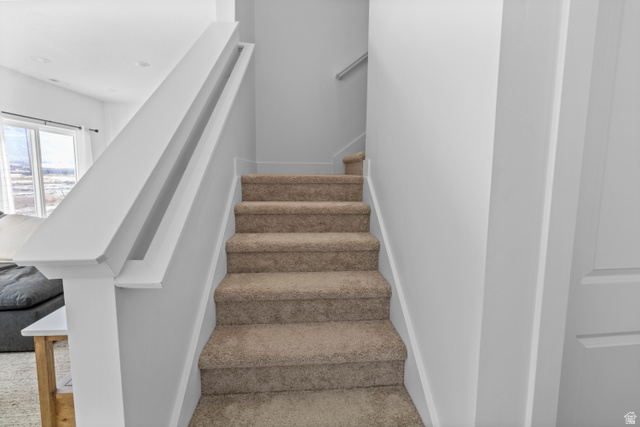 1264 West 500 South, Unit 320 Logan, UT 84321 - Photo 11 of 39 Carpeted staircase with white railings and light gray wall paint
