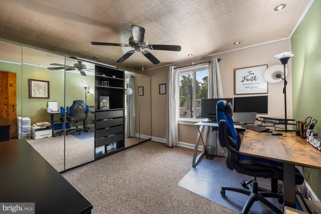 a view of a workspace with furniture and a window