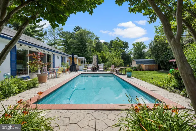 swimming pool view with a seating space and a garden view