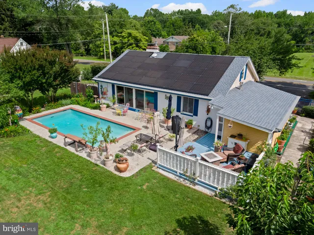 an aerial view of a house with swimming pool garden view and trees