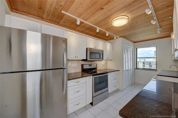 a large kitchen with stainless steel appliances granite countertop a sink and cabinets