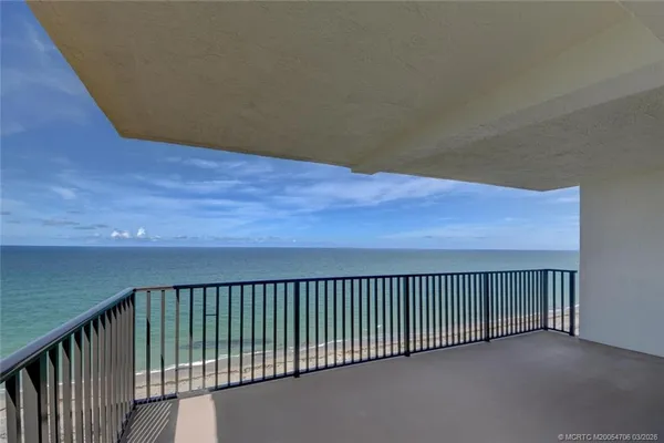 a view of a balcony with a yard