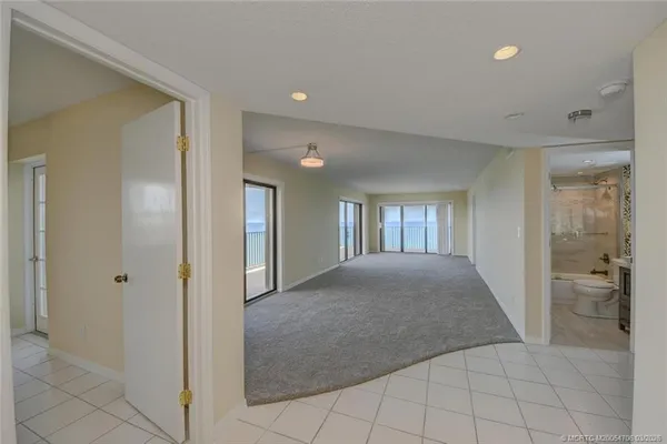 a view of hallway with windows and bathroom