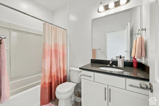 7939 Seattle Slew Road Eagle Mountain, UT 84005 - Photo 25 of 52 Bathroom featuring a white vanity with brushed nickel hardware, an integrated sink, a dark countertop, and a shower-over-tub combination