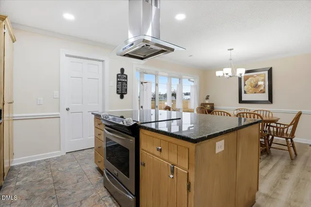 a kitchen with stainless steel appliances kitchen island granite countertop a kitchen island hardwood floor and a sink