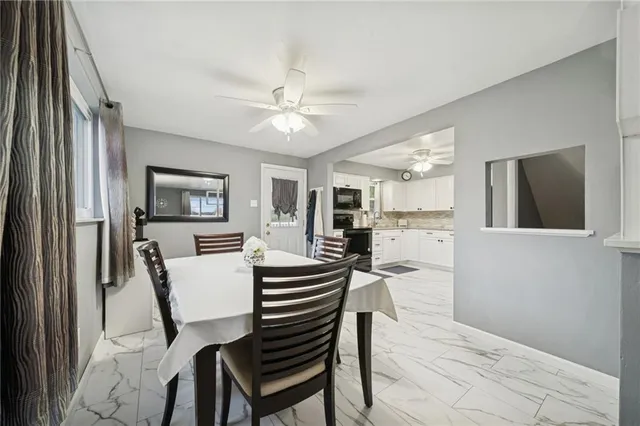 a view of a workspace with furniture and a chandelier fan
