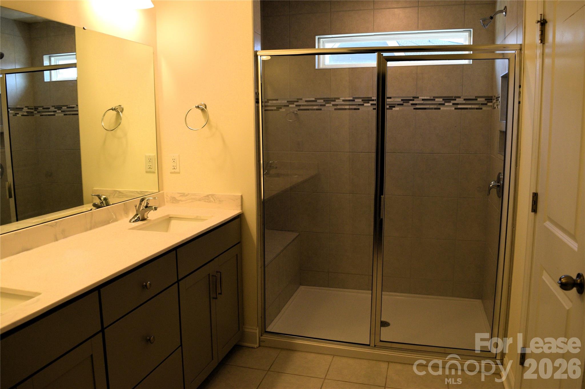 4011 Rothwood Lane Harrisburg, NC 28075 - Photo 15 of 29 a bathroom with a shower sink and mirror