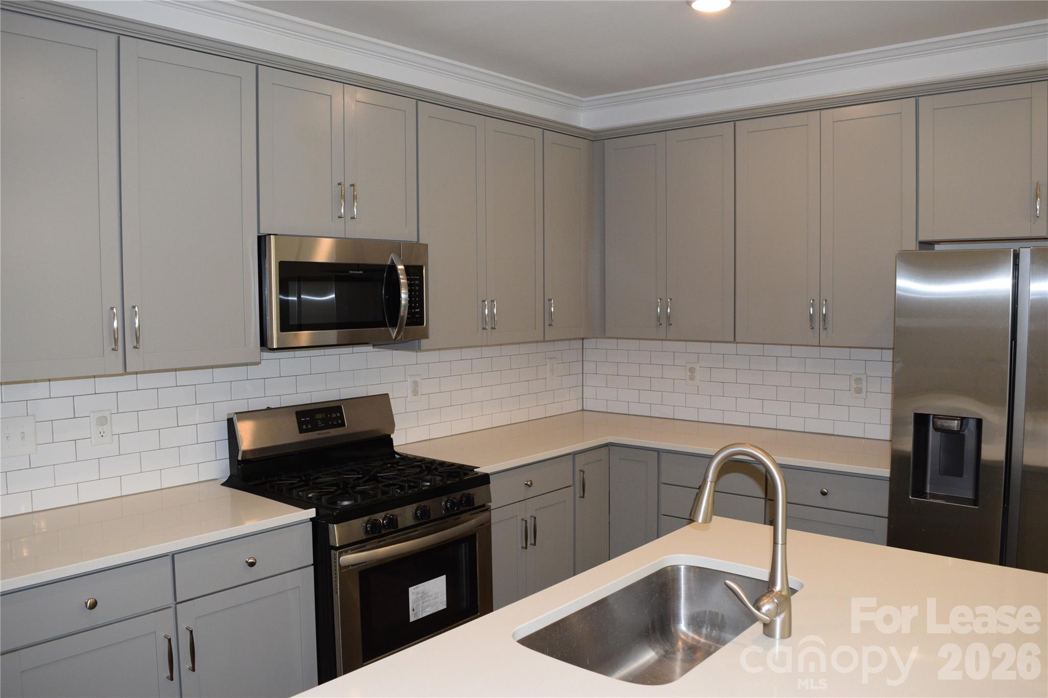 4011 Rothwood Lane Harrisburg, NC 28075 - Photo 6 of 29 a kitchen with granite countertop a sink a stove and cabinets
