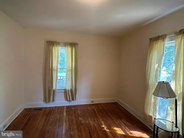 an empty room with wooden floor and a window