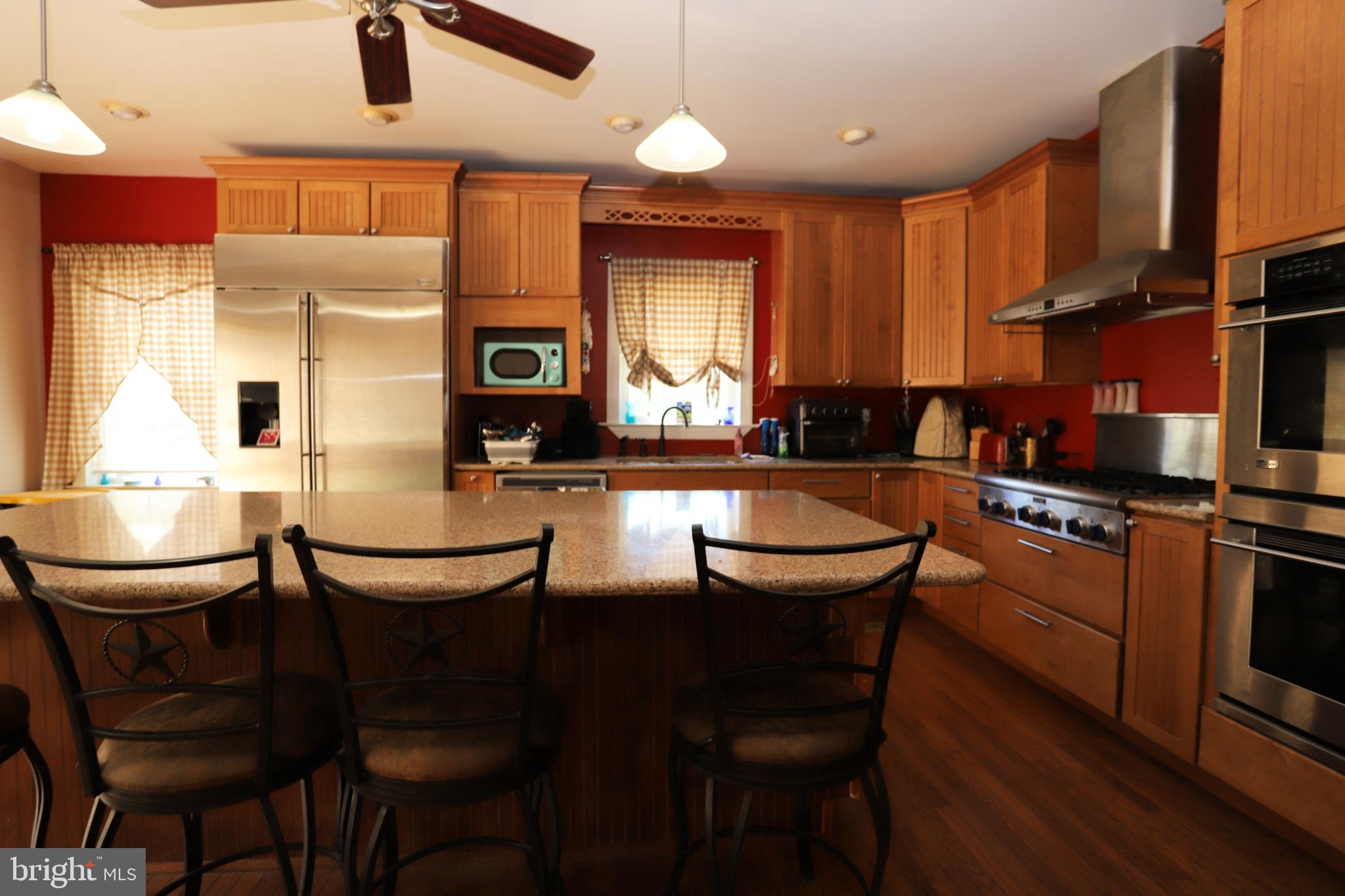 23202 Village Road Unionville, VA 22567 - Photo 6 of 28 a kitchen with stainless steel appliances granite countertop a kitchen island hardwood floor sink stove dining table and chairs