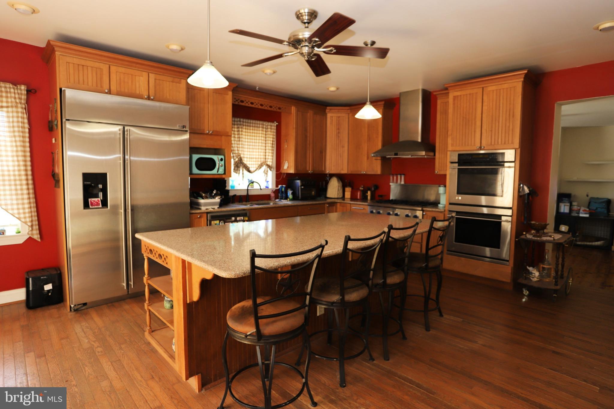 23202 Village Road Unionville, VA 22567 - Photo 8 of 28 a kitchen with stainless steel appliances granite countertop a table chairs and a refrigerator