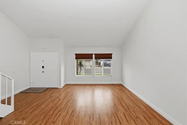 a living room with furniture a flat screen tv and floor to ceiling window